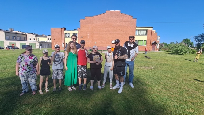Cilvēku grupa pozē brīvā dabā