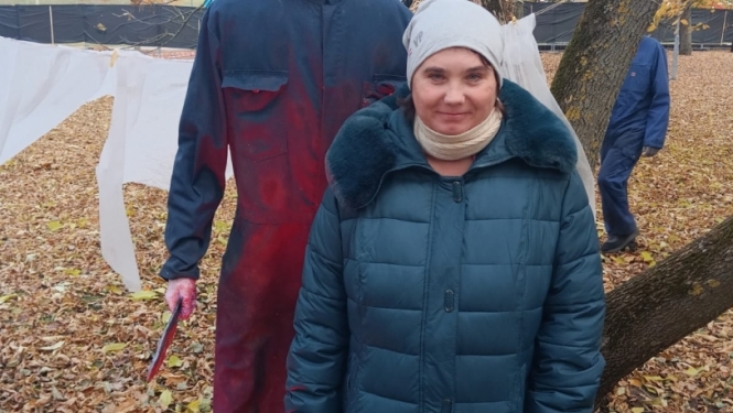 apmeklētāji ar šausmu parka dekorācijām