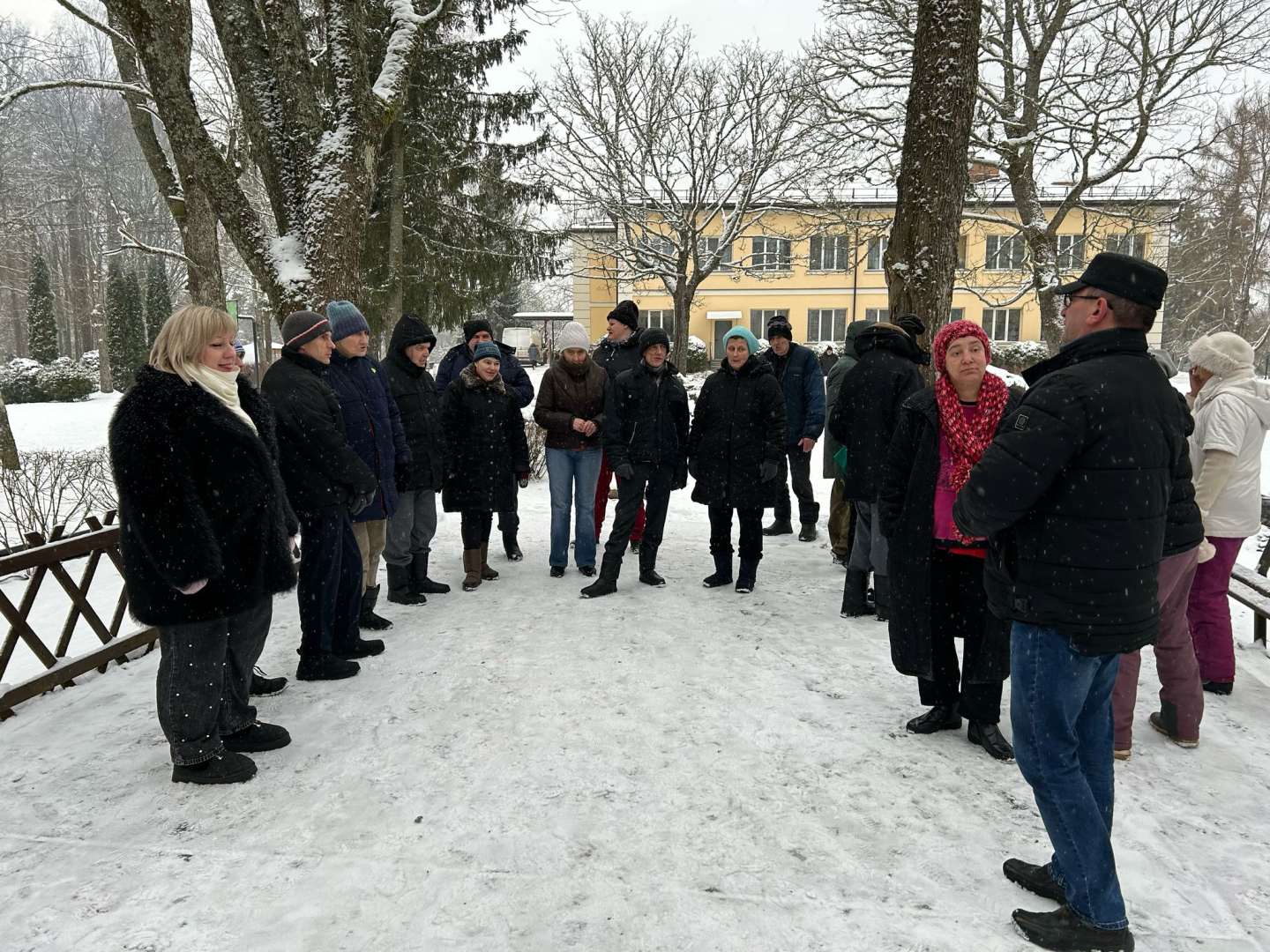 Cilvēki ārā ziemā stāv puslokā