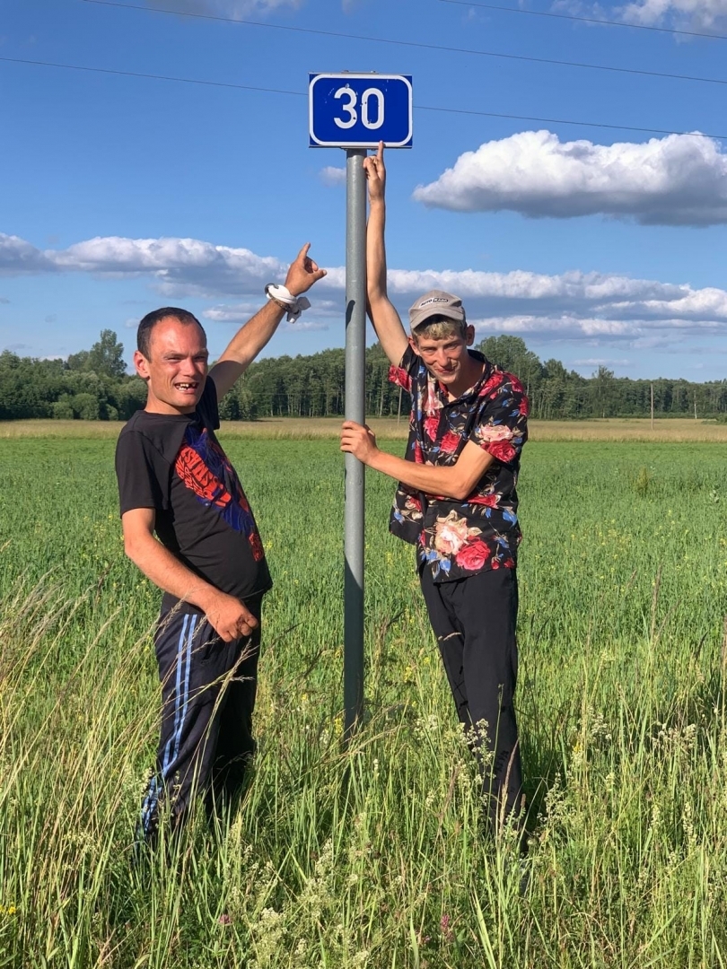 Cilvēki pie kilometru rādītāja