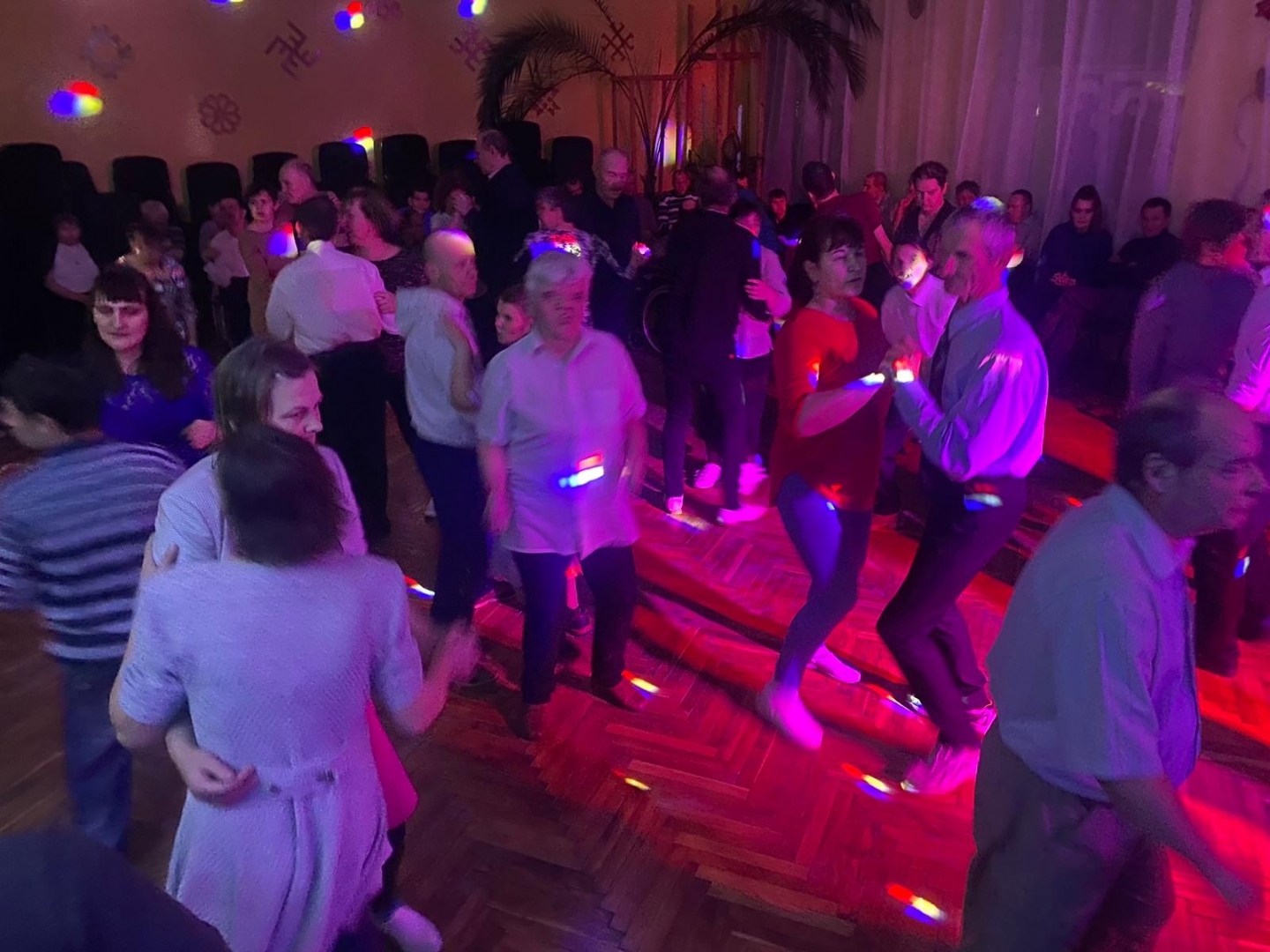 Cilvēki ziemassvētku pasākumā dejo