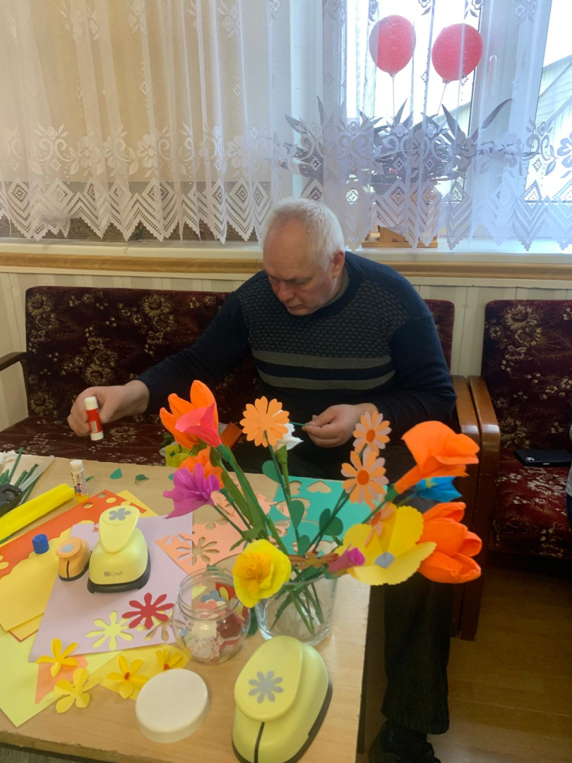 Vīrietis veido papīra dekorācijas, ziedus