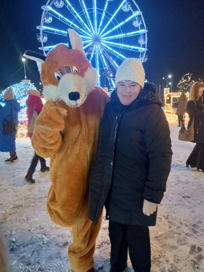 Cilvēki naksnīgā izgaismotā pilsētā