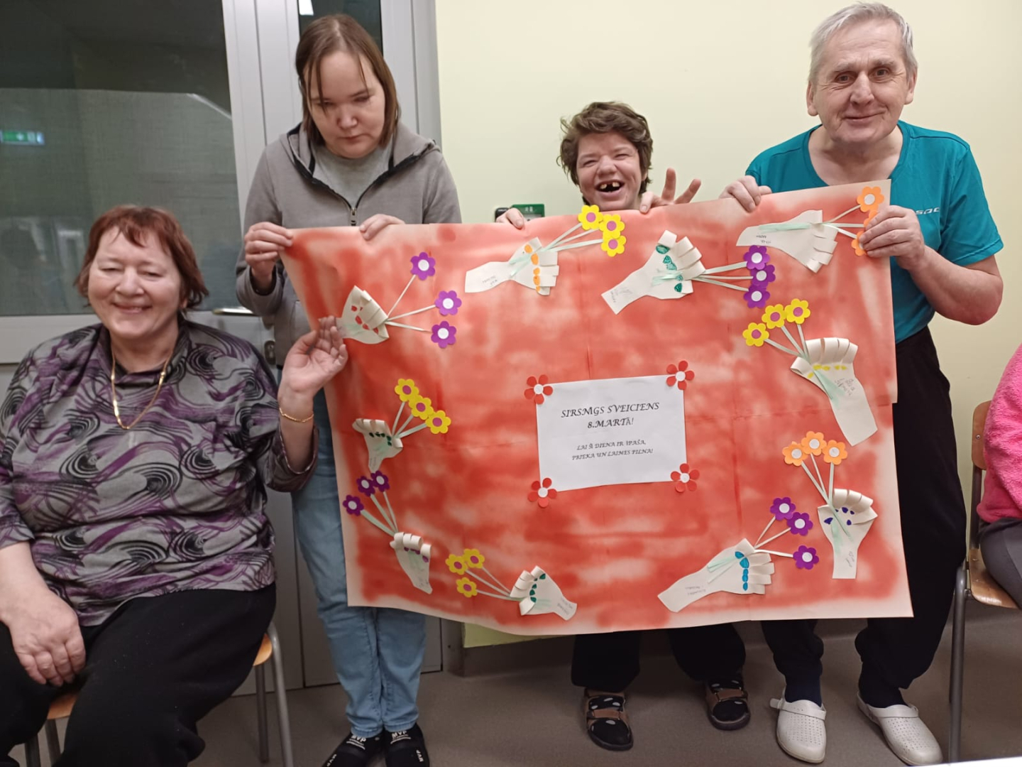 Cilvēku grupa ar 8. marta plakātu rokās
