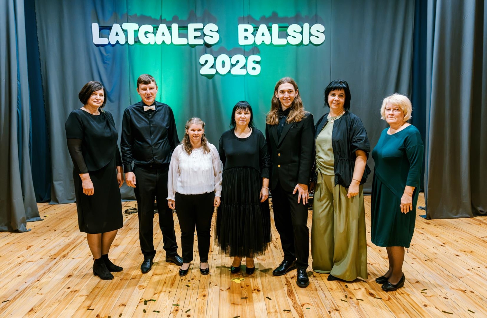 Filiāles Litene dalībnieki uz skatuves un filiāles vadītāja