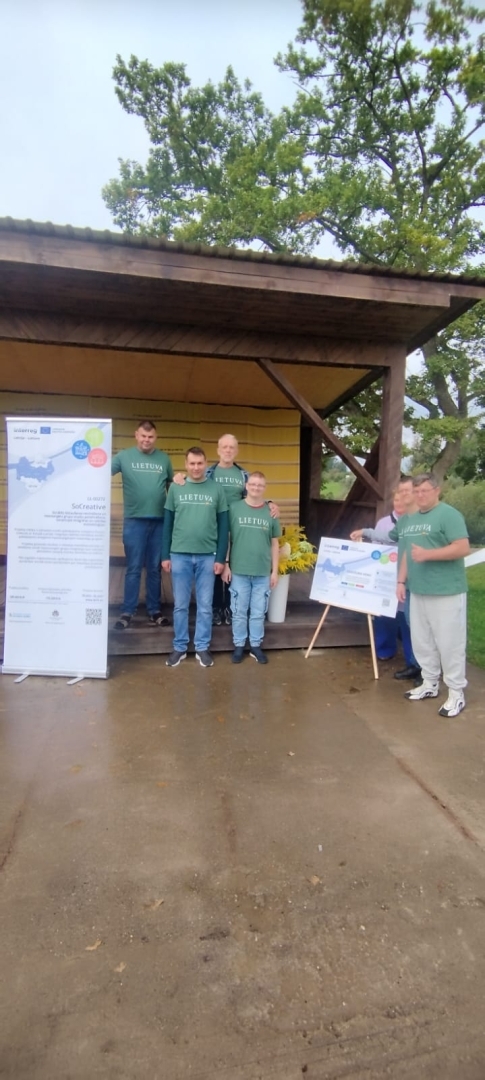 Cilvēki stāv projekta baneriem uz āra skatuves