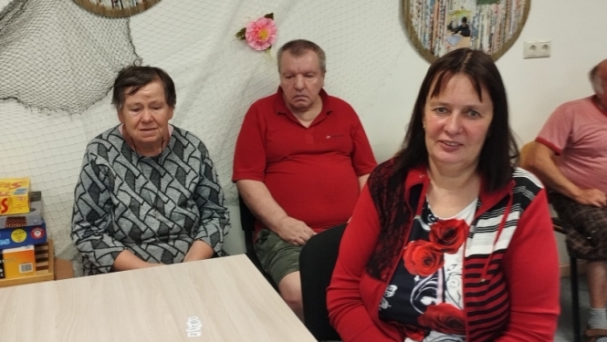 Cilvēku grupa sēž pie galda