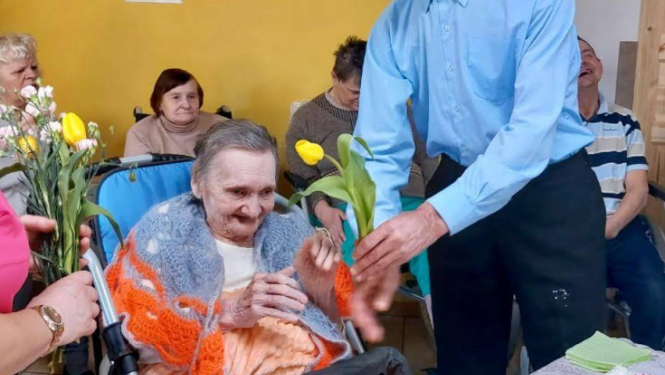 Vīrietis sveic sievieti ar ziediem