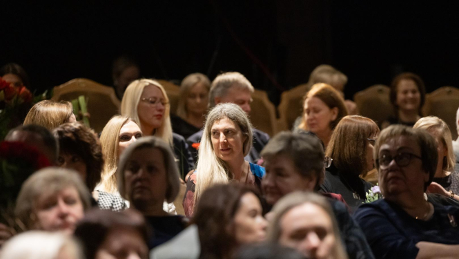 Cilvēki sēž zālē