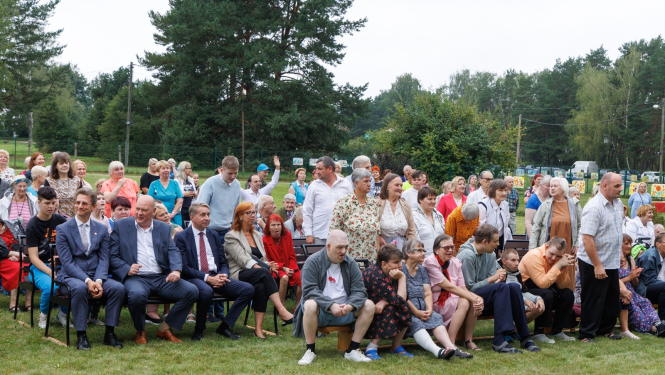 Cīlvēku pūlis ārā zālītē