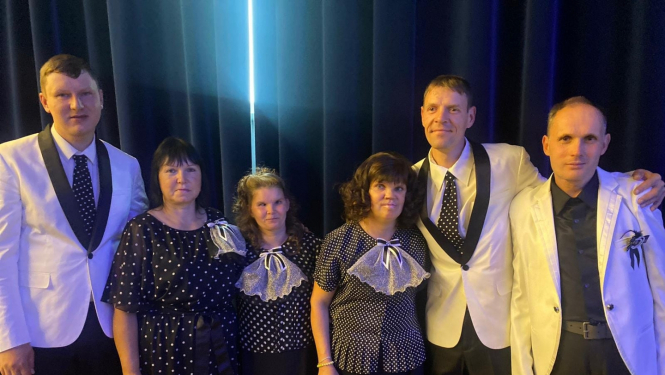 Dziedātāji uz skatuves svētku tērpos