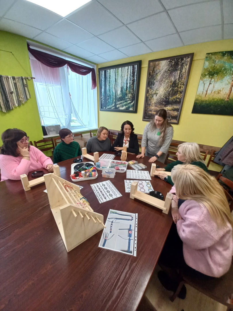 Cilvēki pie galda veido rokdarbus