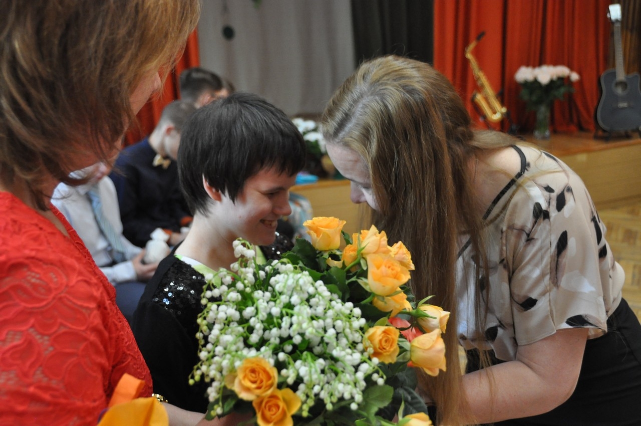 absolventu sveikšana ar ziediem