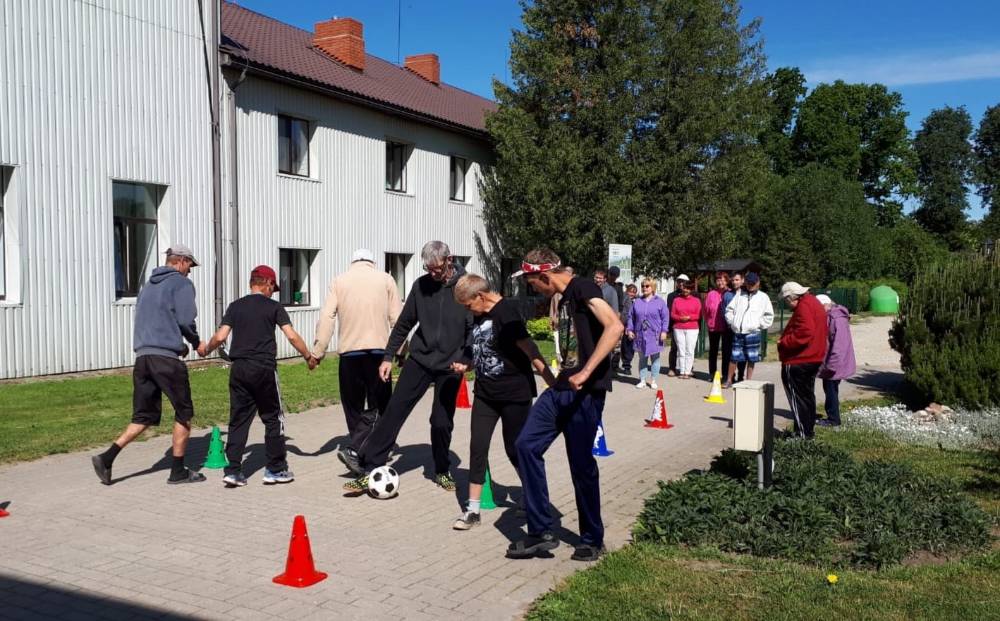 vīrietis driblē futbola bumbu starp konusiem