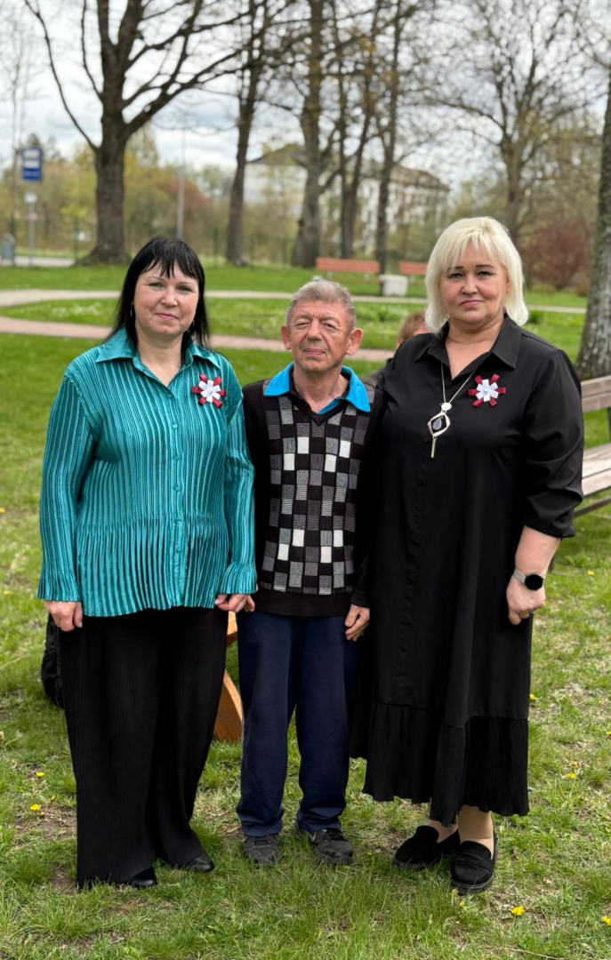 3 sievietes stāv laukā zālājā