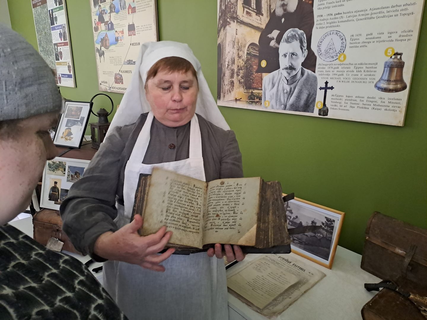 Sieviete rāda cilvēkiem senu grāmatu