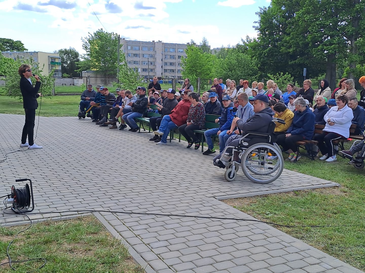 Sieviete uzrunā sēdošu klausītāju grupu