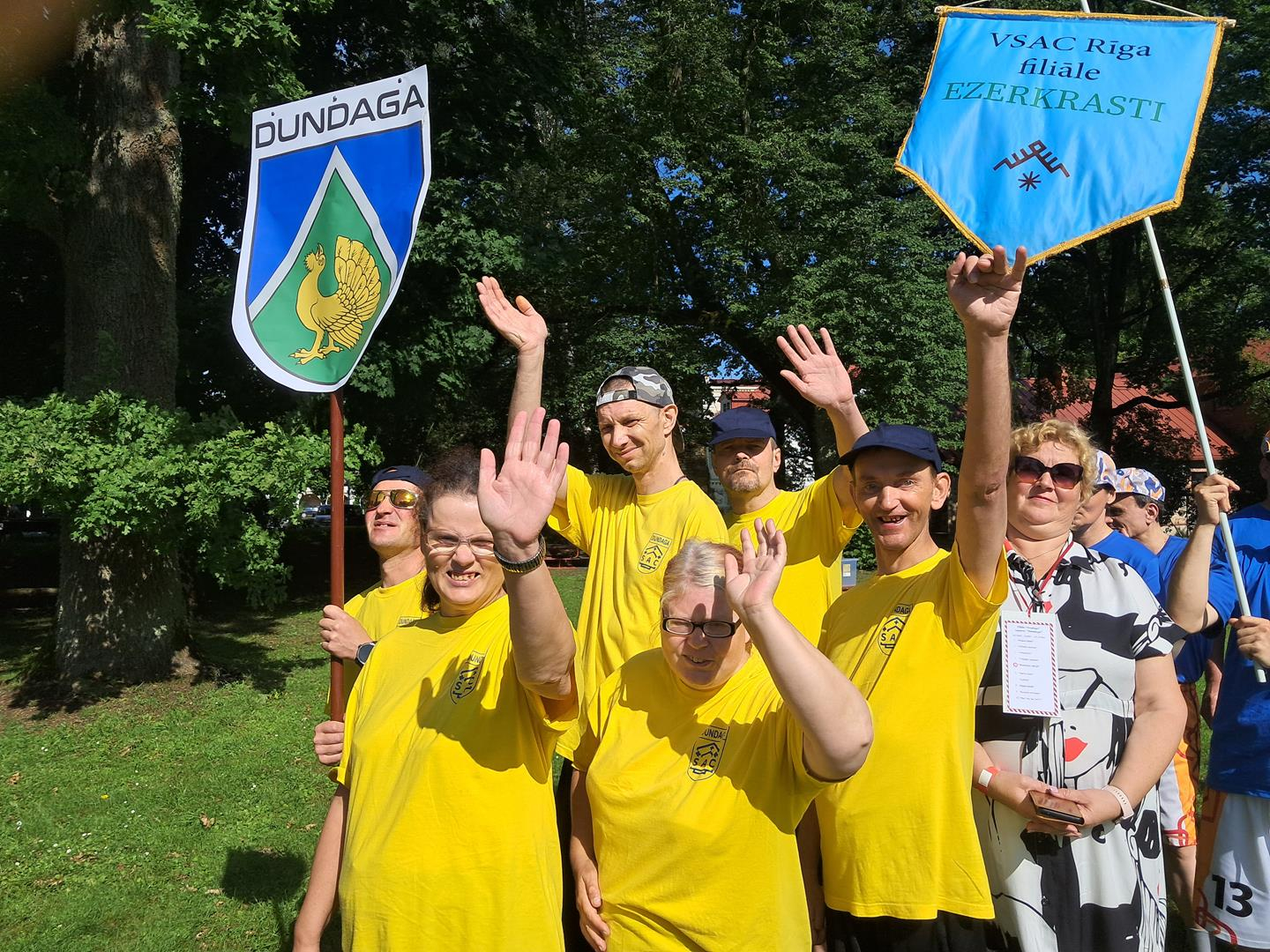 Sportisti gājienā, nes vimpeļus