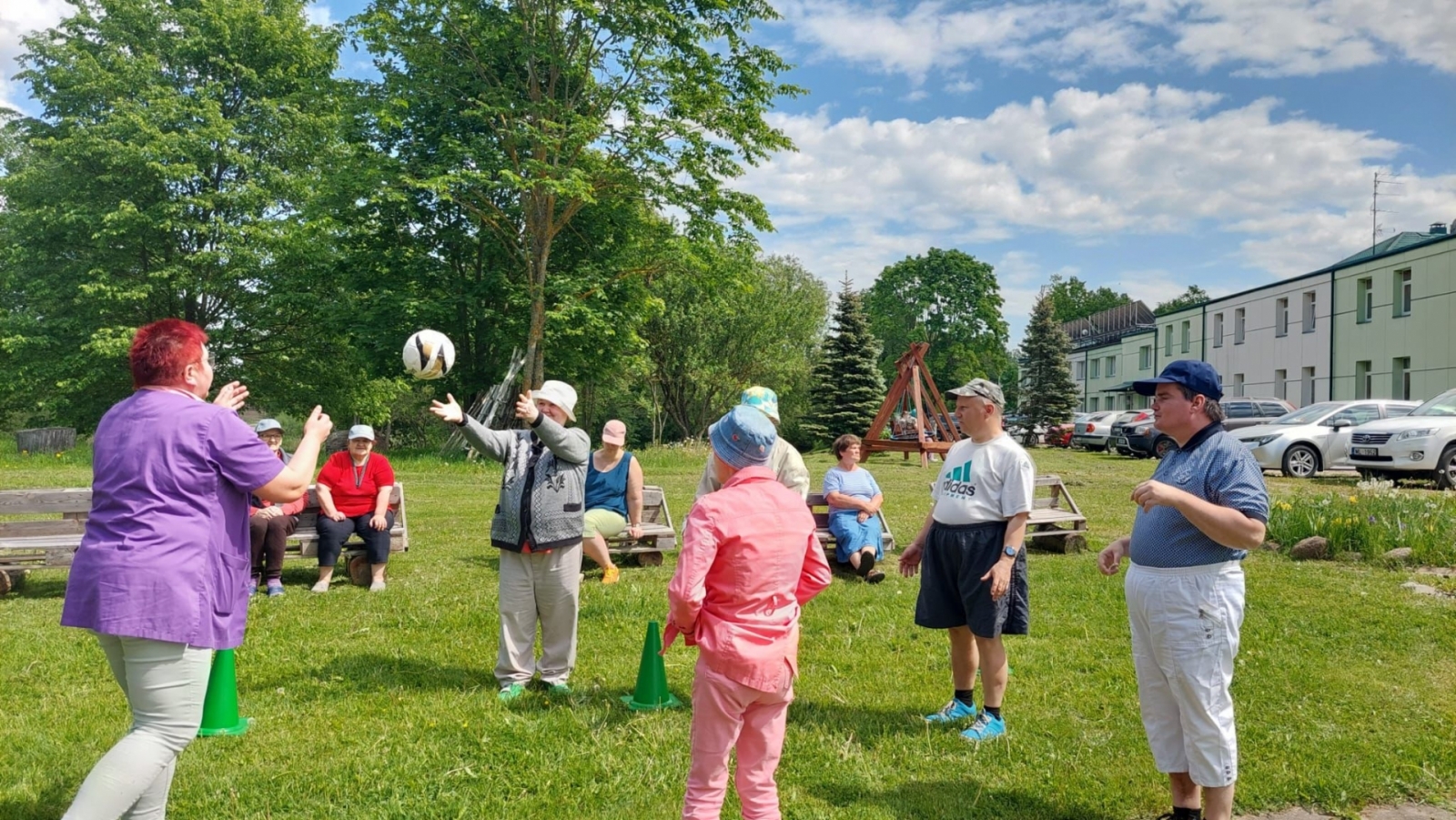 Cilvēku grupa spēlē bumbu