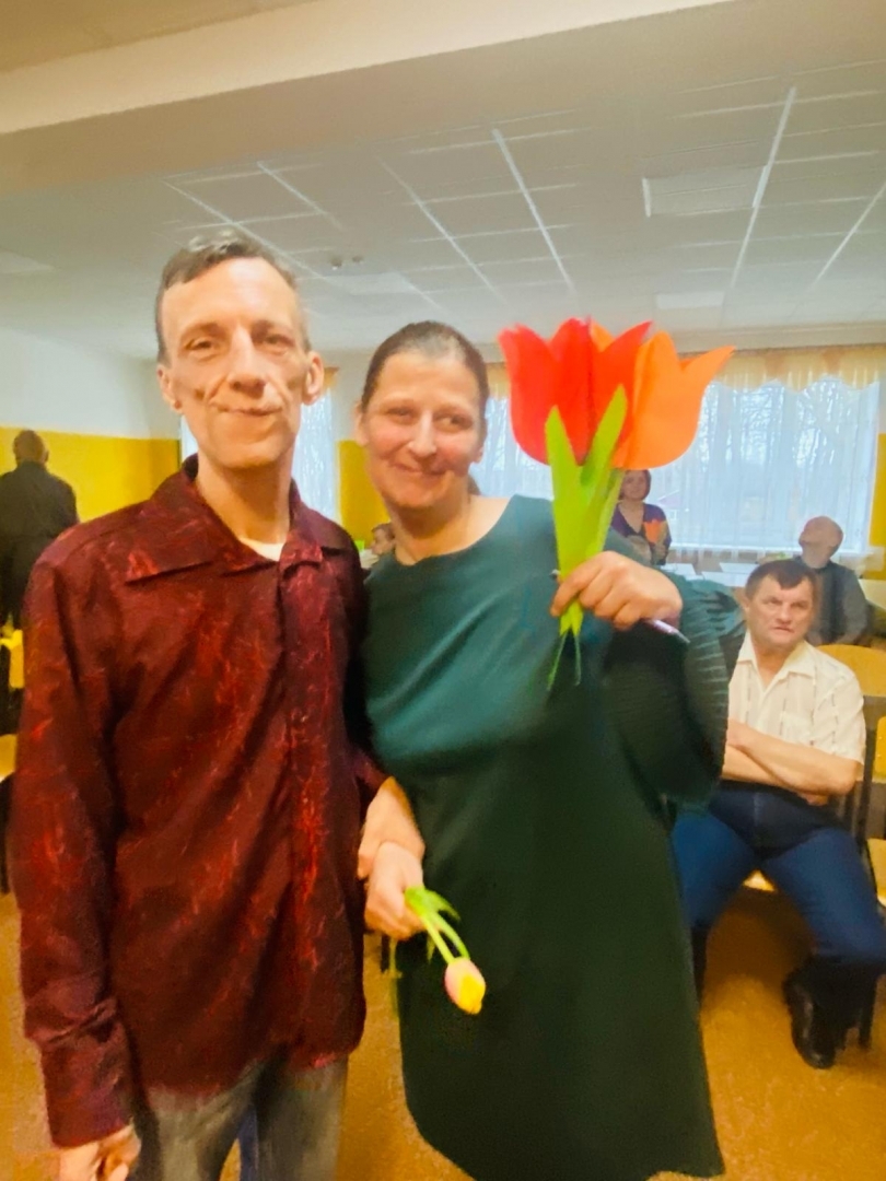 8. marta sveiciens sievietēm, vīrietis un sieviete ar ziediem