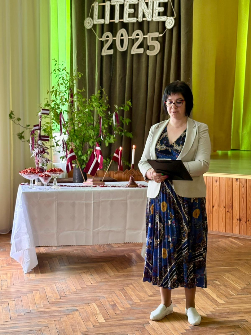Sieviete runā zālē, skatītāju priekšā