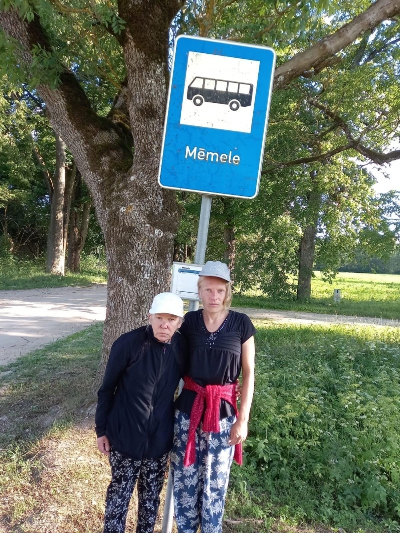 Cilvēki autobusa pieturā