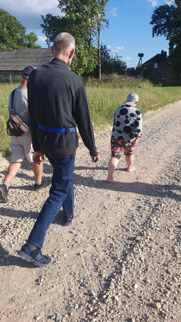 Cilvēku grupa uz grants ceļa
