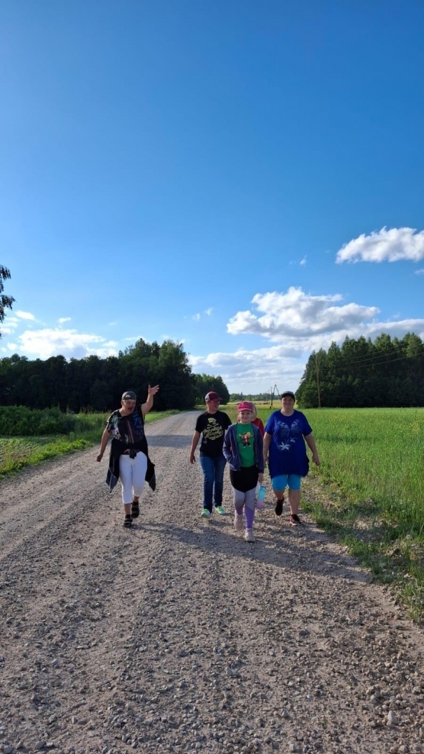 Cilvēku grupa uz grants ceļa