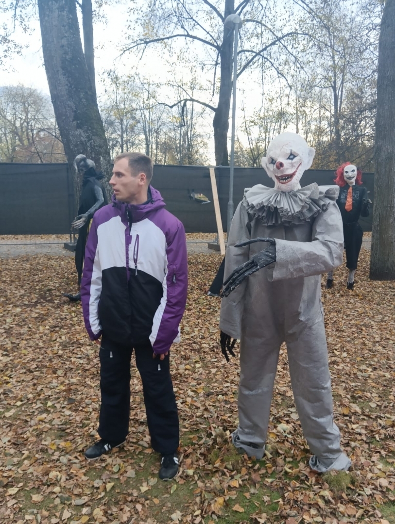 apmeklētāji ar šausmu parka dekorācijām
