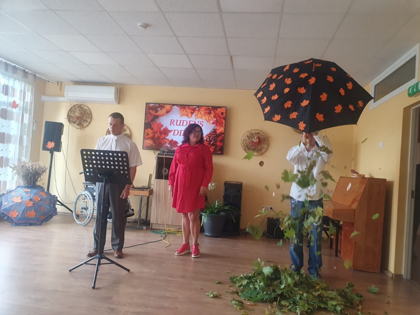 3 cilvēki dzied aktu zālē