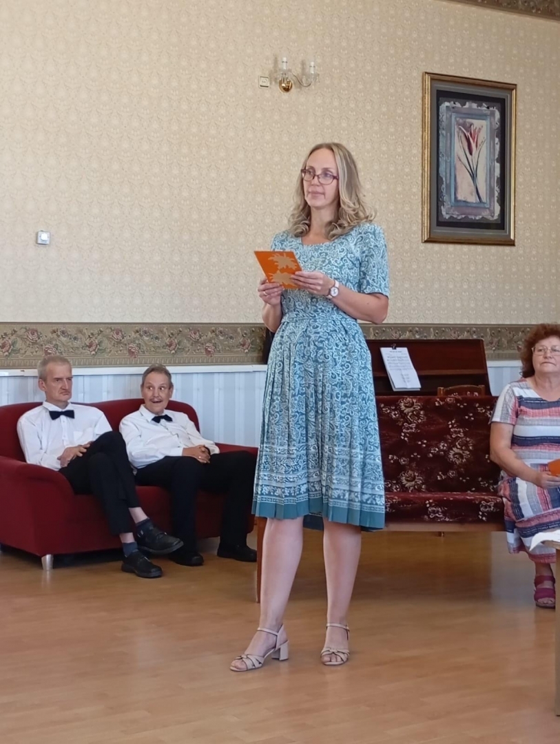 Cilvēki aktu zālē klausās un lasa dzeju