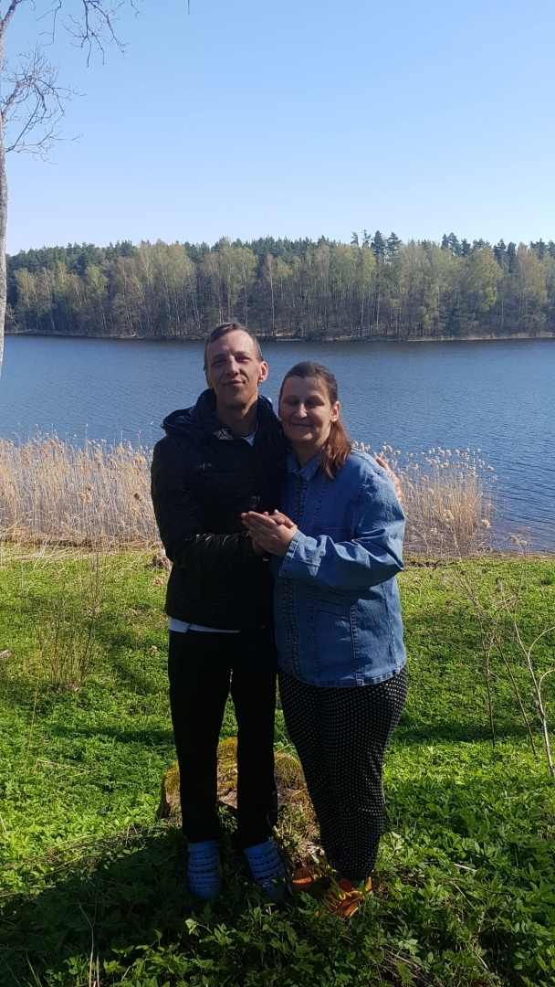 Vīrietis un seviete stāv pie ezera