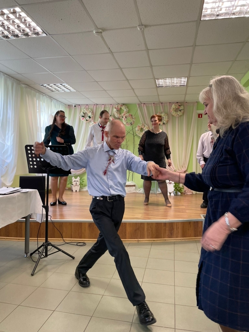 Cilvēki dejo, uz skatuves dziedātāji