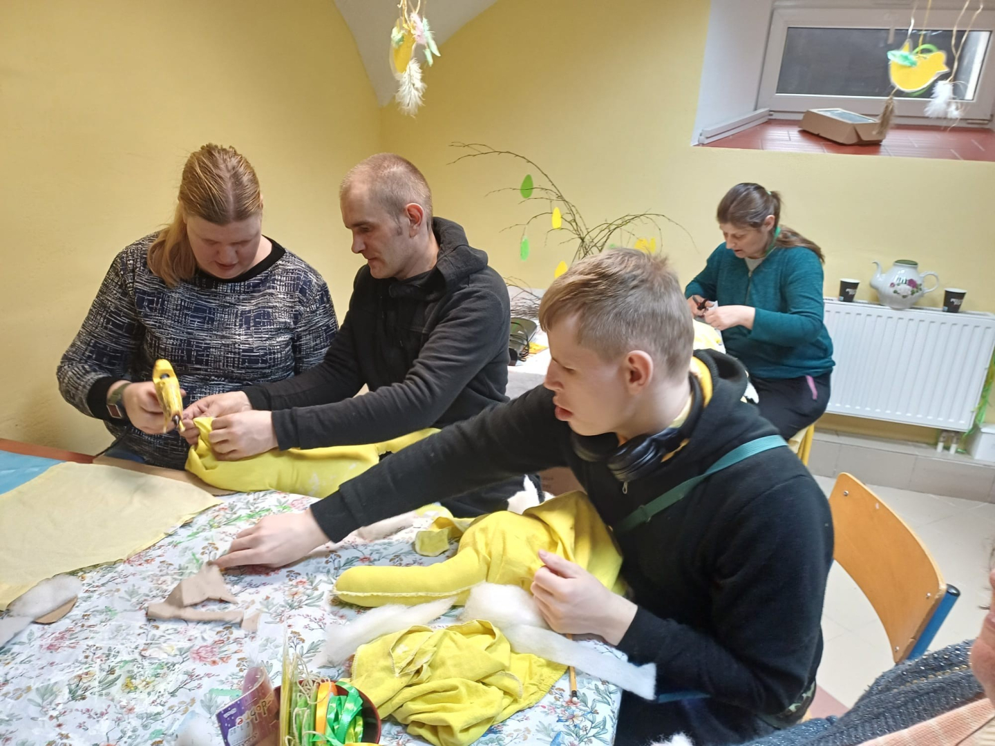 Cilvēku grupa veido Lieldienu dekorācijas