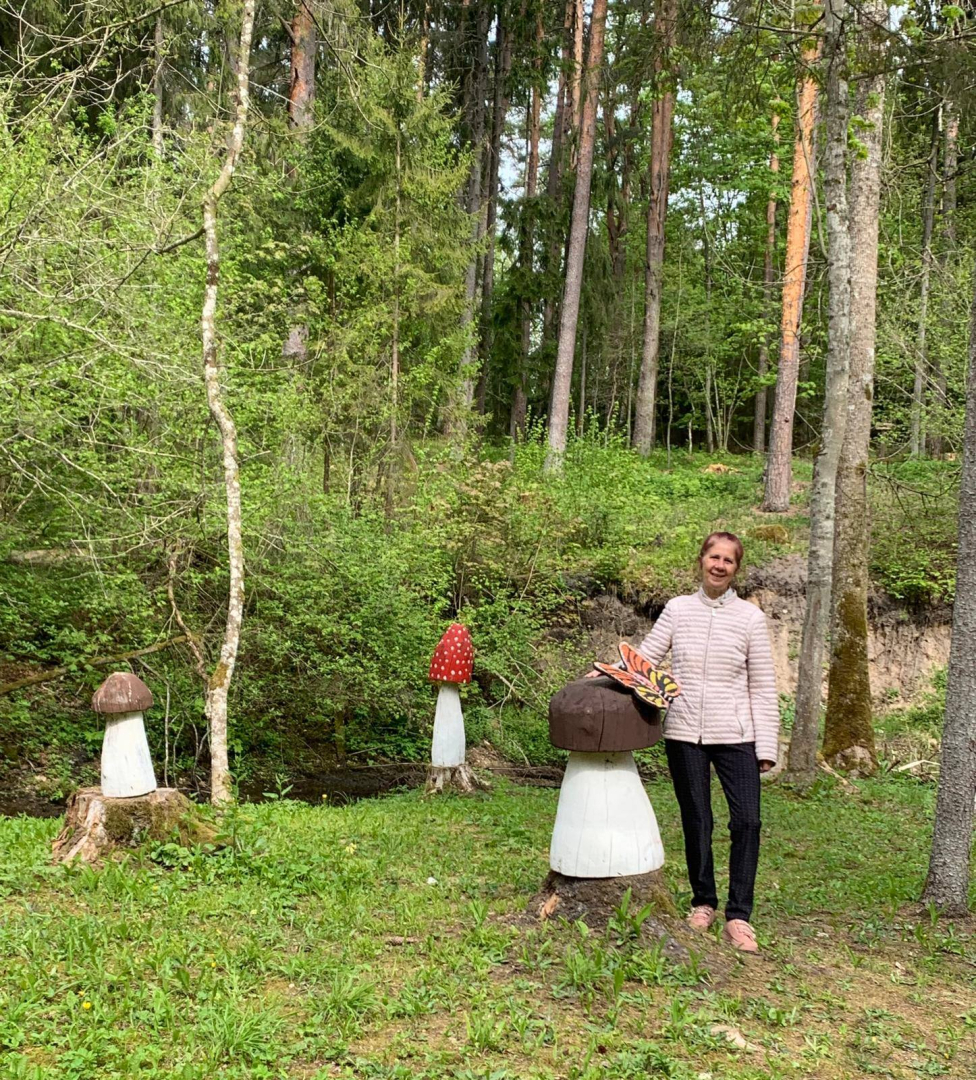 Sieviete pie vides objektiem- lielām koka sēnēm