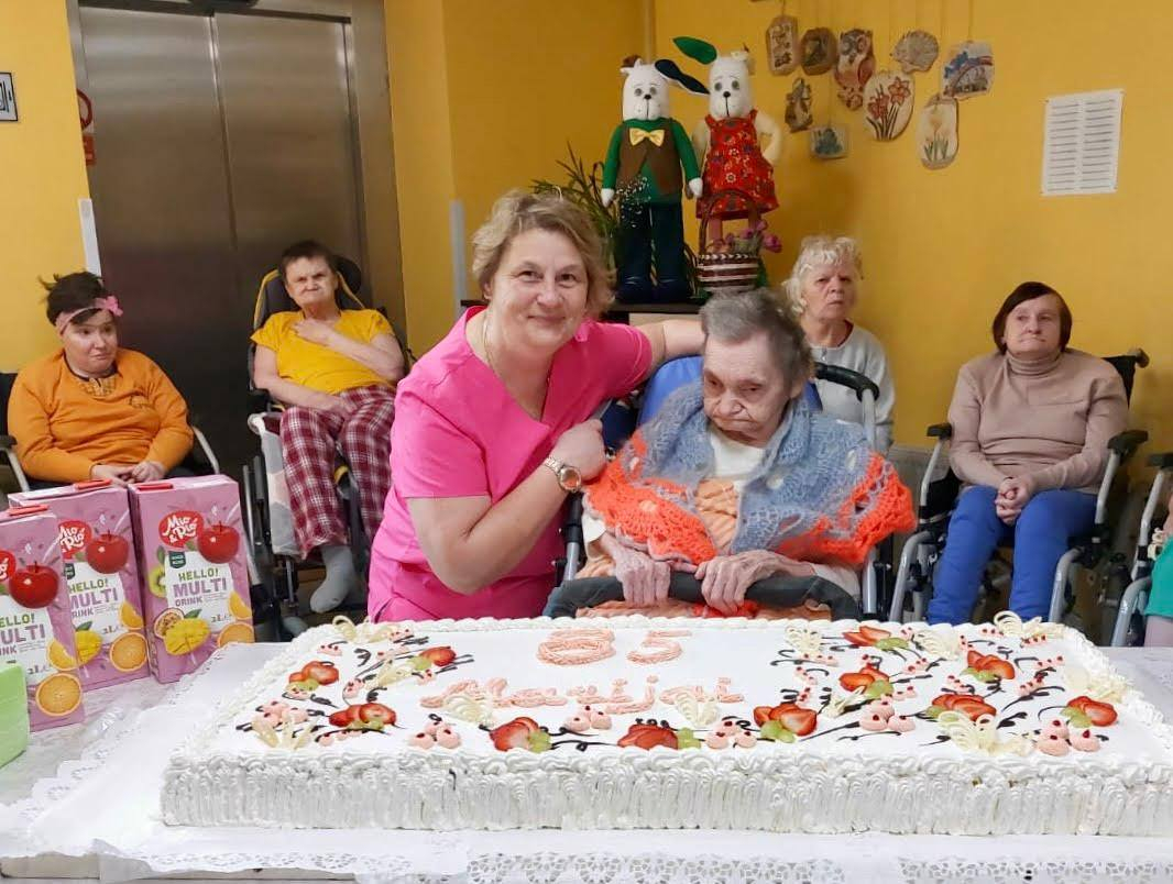 Cilvēku grupa pie svētku tortes