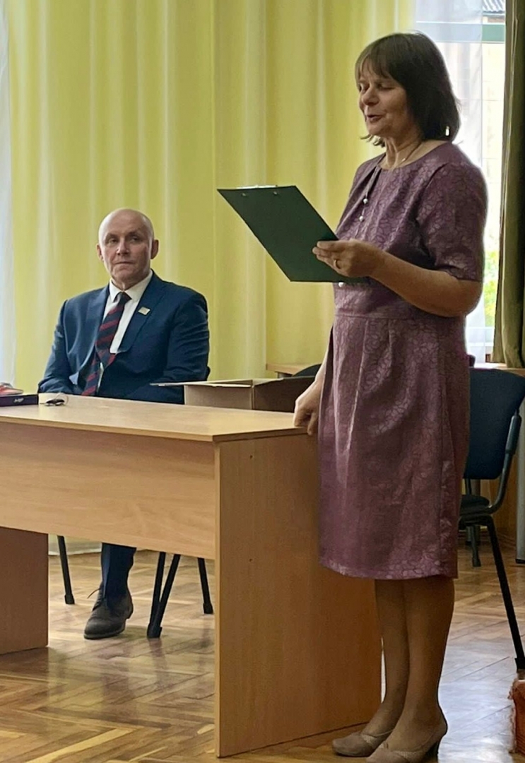 Sievieta lasa runu, stāvot pie galda