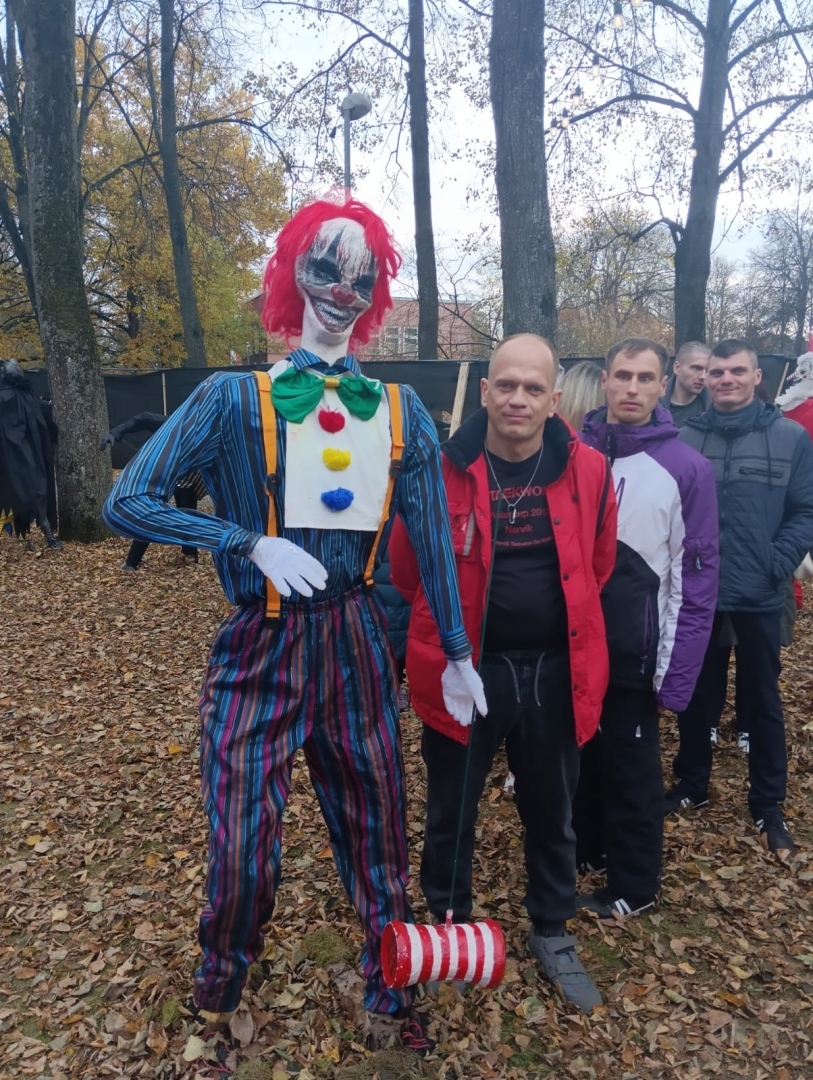 apmeklētāji ar šausmu parka dekorācijām