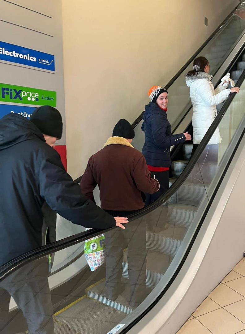 Klienti brauc ar eskalatoru