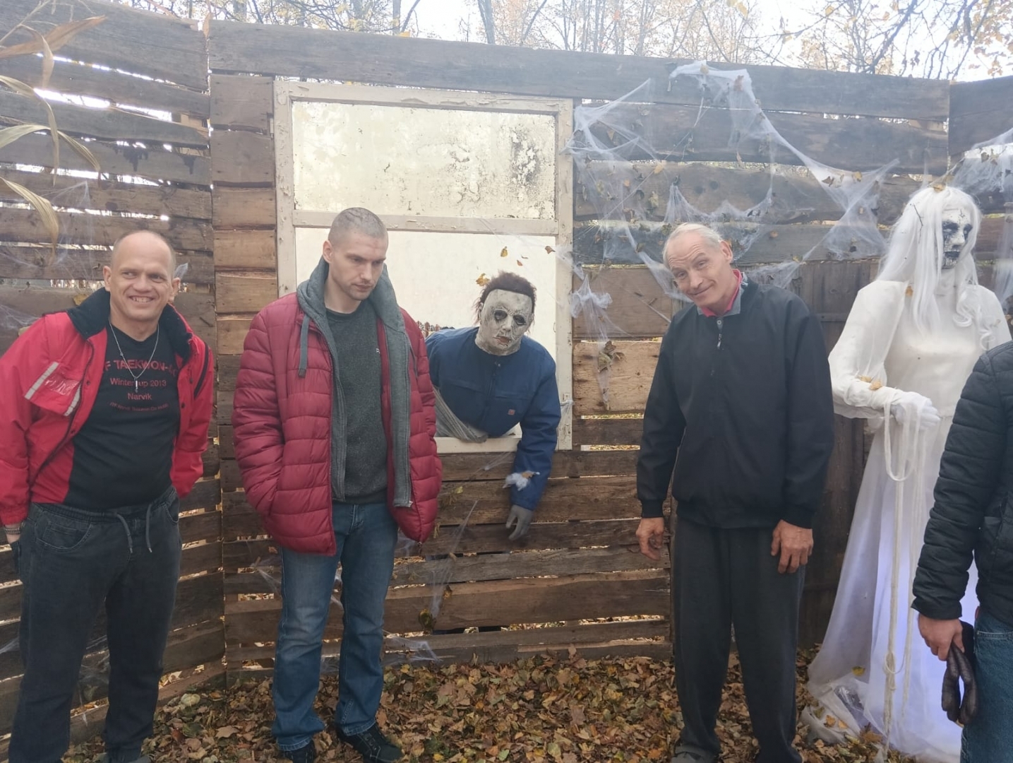 apmeklētāji ar šausmu parka dekorācijām
