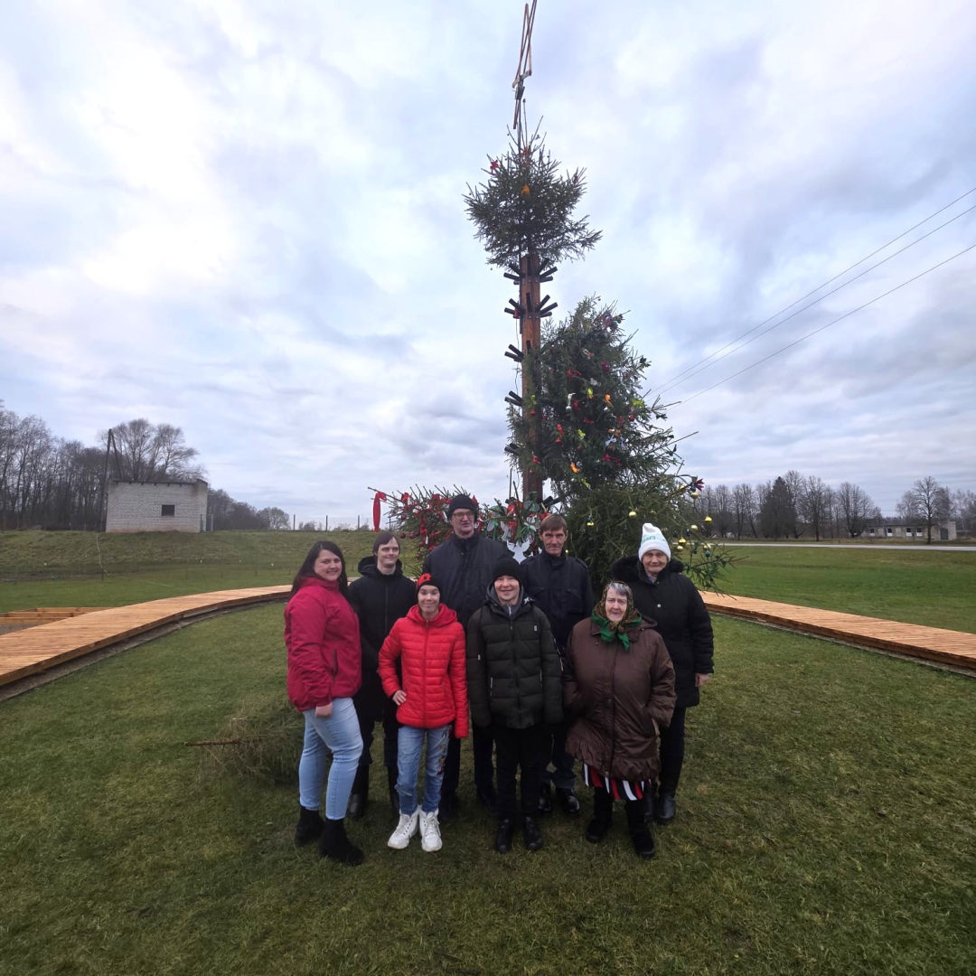 Cilvēku grupa pie ziemassvētku egles