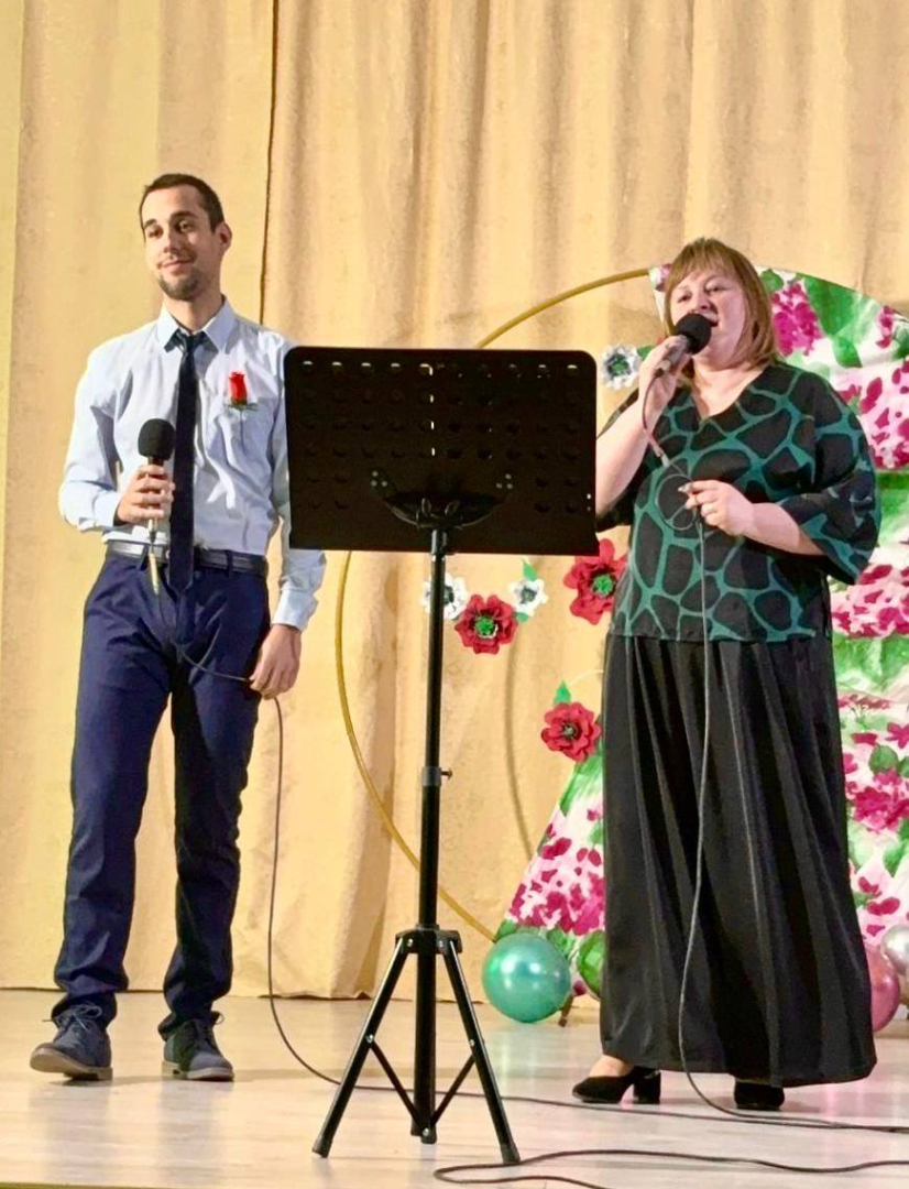 sievie un vīrietis uz skatuves dzied