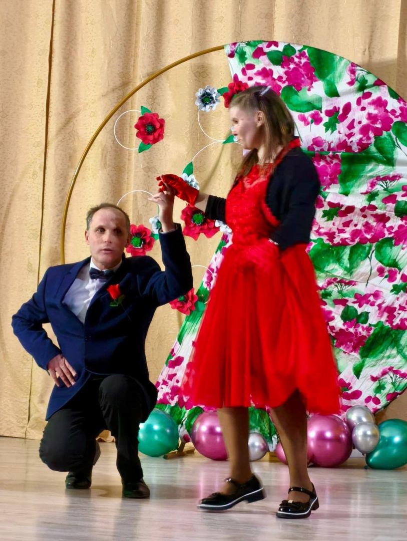 vīrietis dejo ar sievieti sarkanā kleitā