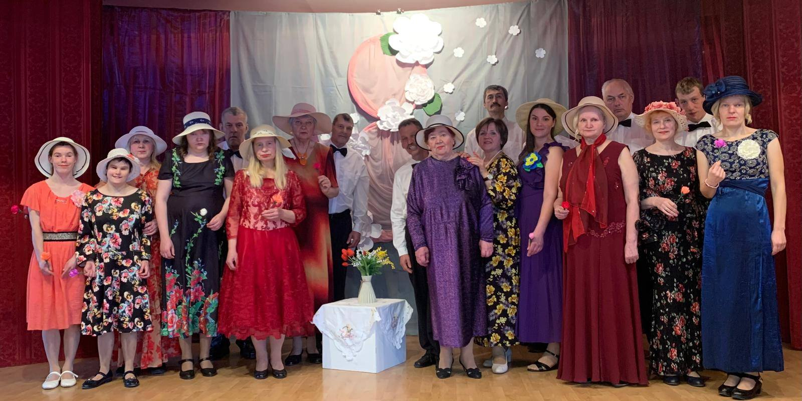 Sieviešu grupa uz skatuves svētku kleitās