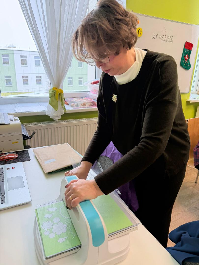 Cilvēki pie galda veido rokdarbus