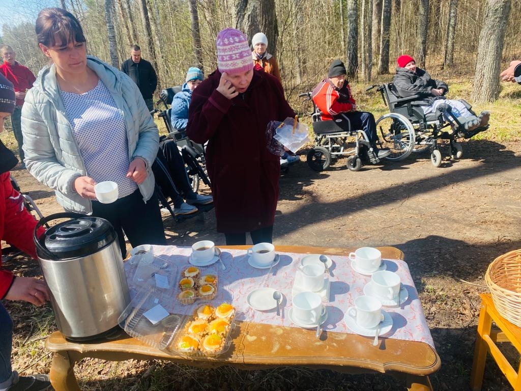 2 cilvēki stāv pie galda ar tēju un ēdienu