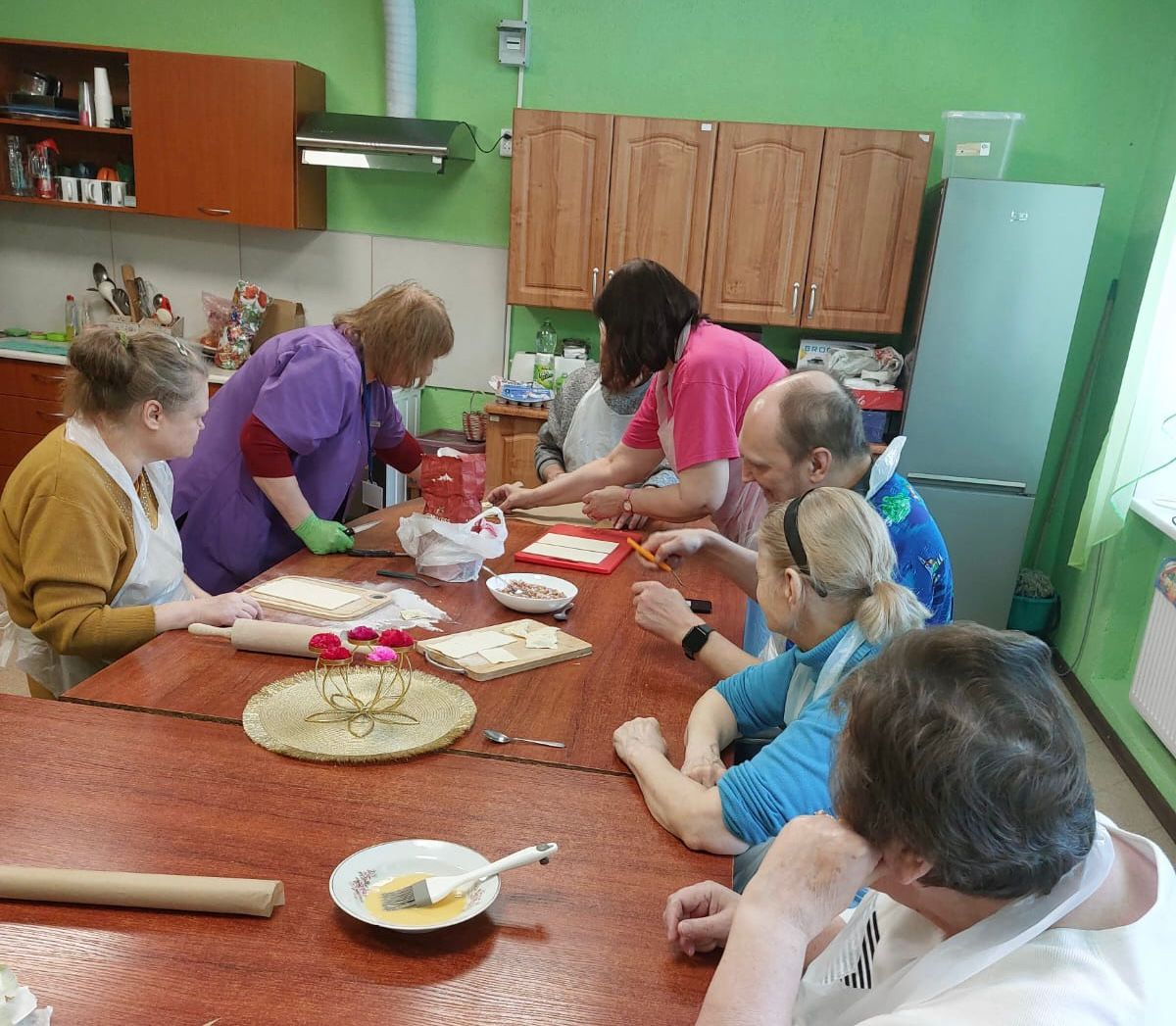 Pīrāgu gatavošana, cilvēki ap galdu