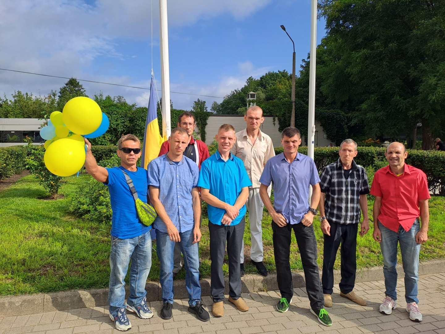 Cilvēki ar baloniem rokās, fon;a ukrainas karogs