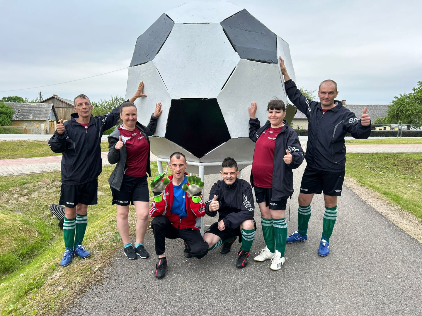 Cilvēku grupa ar lielu improvizētu futbola bumbu