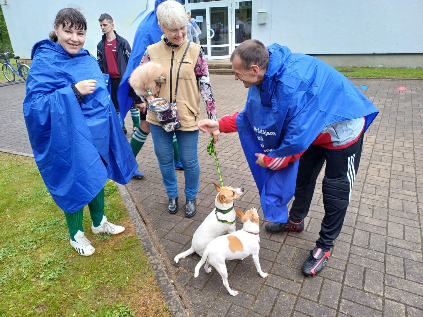 Cilvēki ārā spelējas ar suņiem